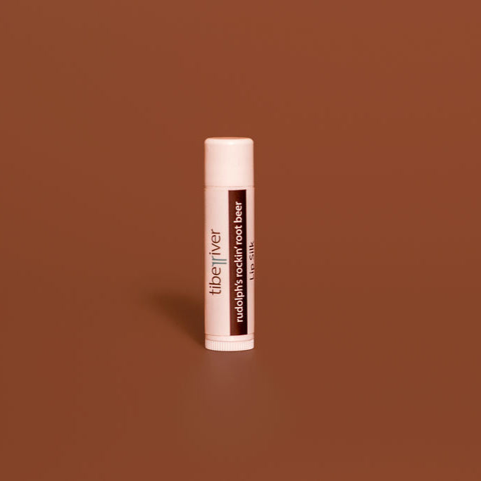 Lip balm tube with 'tiberiver' branding on a brown background